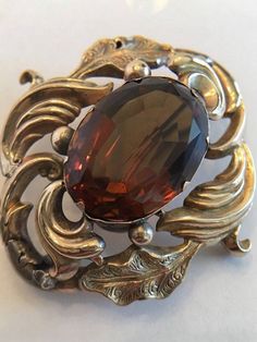 "This is a Very Special Piece. Probably the oldest piece in my inventory. This is an Antique Georgian Brooch with a Large Amber/Brown Topaz in the Center. It is possible it is a Paste Stone. It also has an open hook in the back, at the top, so it can be worn as a pendant if desired. This piece is really well made and in very good condition considering its age. The piece is tested to be 9K Yellow Gold. The large stone is about 1 3/4 \" x 1 3/4\" tall. It weighs 10.7 grams without the stone. I am Ornate Formal Brooches Hallmarked, Ornate Hallmarked Brooches For Formal Occasions, Baroque Brooch For Formal Occasion, Elegant Baroque Brooches For Formal Occasions, Ornate Brooches With Intricate Design For Formal Occasions, Formal Baroque Brooch, Ornate Yellow Gold Brooch For Formal Occasions, Victorian Style Formal Brooches, Ornate Baroque Brooches For Formal Occasions