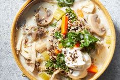 a bowl of soup with mushrooms, carrots and kale