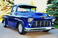 an old blue truck is parked in the driveway