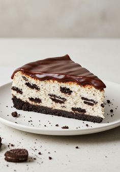 a piece of cake sitting on top of a white plate next to oreo cookies