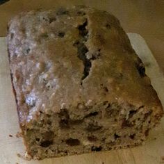 a loaf of banana bread sitting on top of a cutting board next to a knife