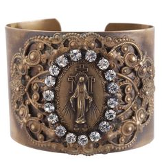 a bracelet with an image of the virgin mary on it and crystal stones in the center