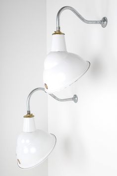 two white lamps are hanging on the wall