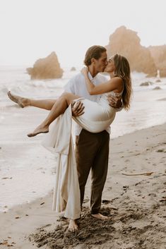 a man carrying a woman on his back at the beach