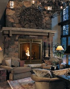 a living room filled with furniture and a fire place next to a stone fireplace mantle