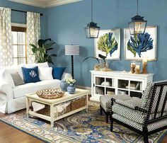 a living room with blue walls and white furniture