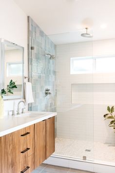 a bathroom with a sink, mirror and shower in it's center area is shown