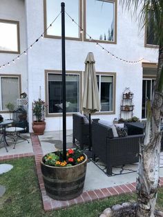 an outdoor patio with chairs, umbrella and potted plants