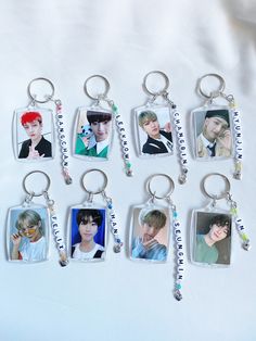 six keychains with pictures of the same person hanging from each other on a white surface