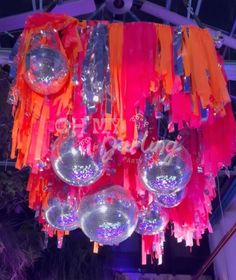 a chandelier hanging from the ceiling in a room with lights and streamers