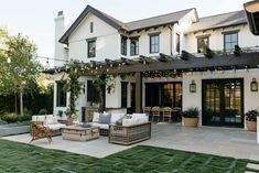 an outdoor living area with patio furniture and string lights on the roof, surrounded by grass