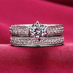 two wedding bands with a diamond ring on top