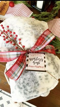 two christmas gifts wrapped in red and white plaid ribbon on top of each other, sitting on a table