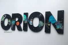 the letters are made out of wood and have planets painted on them in different colors