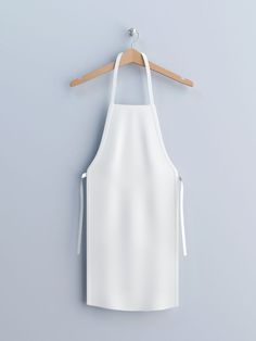 a white apron hanging on a wooden hanger