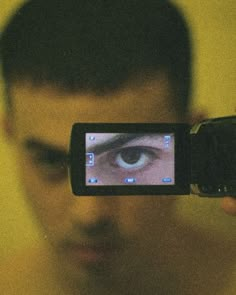 a man holding up a cell phone to take a photo with an eye on it