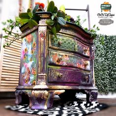 an ornate dresser with flowers and plants on top