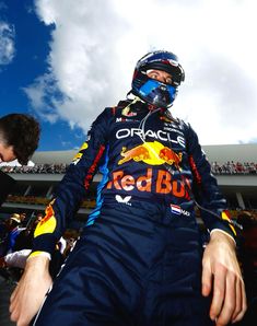 a man sitting on the back of a red bull racing car