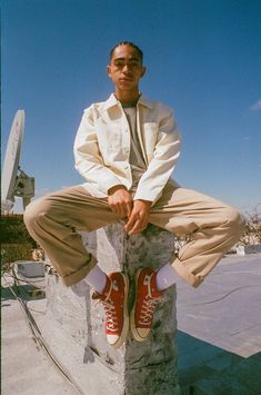 a man sitting on top of a cement block