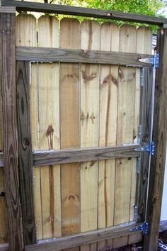 a cat is sitting on the ground next to a wooden fence that has been made out of wood planks