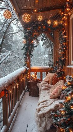 a porch covered in snow with christmas lights and garlands hanging from the ceiling above