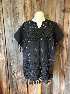 This is a traditional hunter's tunic from the Dogon tribe of Mali, West Africa. It is made of hand spun, handwoven cotton, dyed with natural earth dyes and embellished with silver.  This tunic is new and in excellent shape. A statement piece, excellent for performance on stage. Availability in Black or Brown The black tunics are open on the sides, to style more as a poncho. It is 30 inches from top to bottom. A size small/medium Traditional Cotton Poncho For Festival, Traditional Batik Print Kaftan Tunic, Bohemian Black Thobe Tunic, Traditional Festival Poncho With Woven Motifs, Traditional Black One-size Poncho, Dogon People, Dogon Tribe, Mens Poncho, Bohemian Brown V-neck Tunic