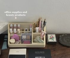 an office supplies and beauty products sit on a desk next to other items, including books