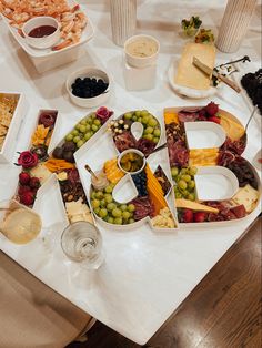 a table topped with lots of different types of food and wine glasses on top of it