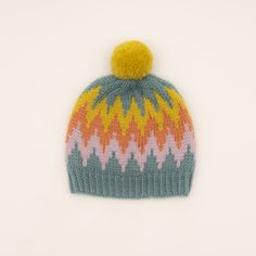 a multicolored knitted hat with a pom - pom