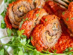 meatballs covered in marinara sauce and parsley on a plate