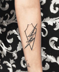 a woman's arm with a tattoo on it that has a lightning bolt in the center