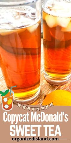 two glasses filled with tea sitting on top of a wooden table