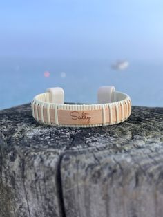 1/2” Nantucket style Cuff with maple wood overlay and acrylic end caps. Lazor engraved "Salty” Text. Text can be customized upon request. Complimentary suede bracelet pouch with box. Unisex - Available in sizes S, M, and L.Materials: maple, cane Adjustable Cream Cuff Bracelet Gift, Adjustable Cream Cuff Bracelet As Gift, Adjustable Cream Cuff Bracelet For Gift, Nantucket Style, Suede Bracelet, Maple Wood, Nantucket, Pouch, Cuff