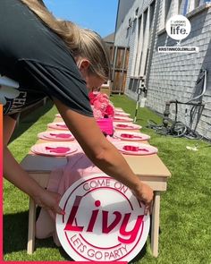 a woman placing plates on top of a table with the words livy on it