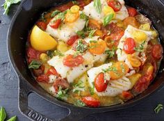 fish with tomatoes and lemon in a skillet