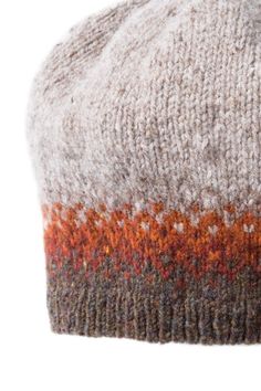 a close up of a knitted hat with orange and grey stripes on the side