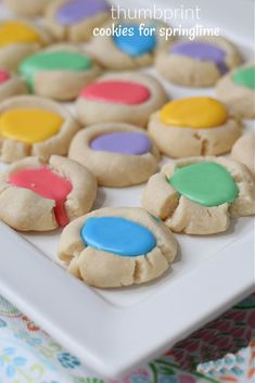 some cookies are on a white plate with colorful frosting