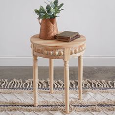 a wooden table with a potted plant sitting on top of it next to a rug