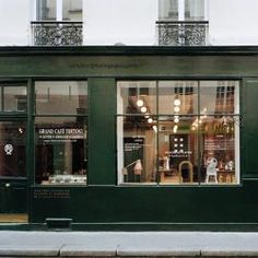 a green store front on the corner of a street