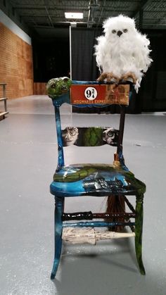 an owl sitting on top of a blue chair in a warehouse with no one around it