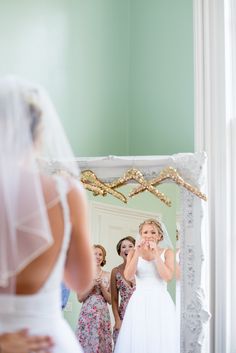 the bride is looking at her reflection in the mirror