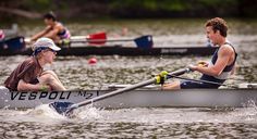 two men rowing in a boat on the water