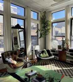 a living room filled with lots of windows and furniture next to each other on top of a checkered floor