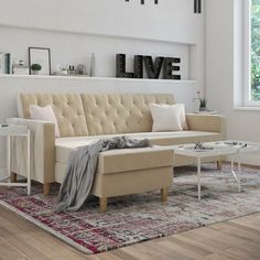 a living room with a couch, coffee table and love letters on the wall above it