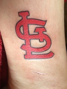 a tattoo on the leg of a person with a red and black st louis logo