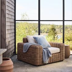 a wicker chair sitting in front of a large window