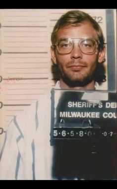 a mug shot of a man with glasses holding a sign that says sheriff's del milwaukee court