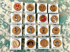 wooden buttons with cartoon characters on them sitting on a carpeted floor next to each other