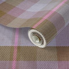 a close up view of a pink and brown checkered wallpaper with a roll of tape