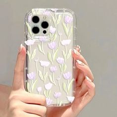 a woman holding up her phone case with flowers on it